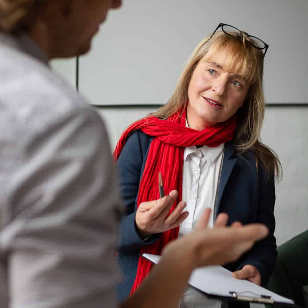 Cornelia Plänitz mit Klemmbrett im Coachinggespräch